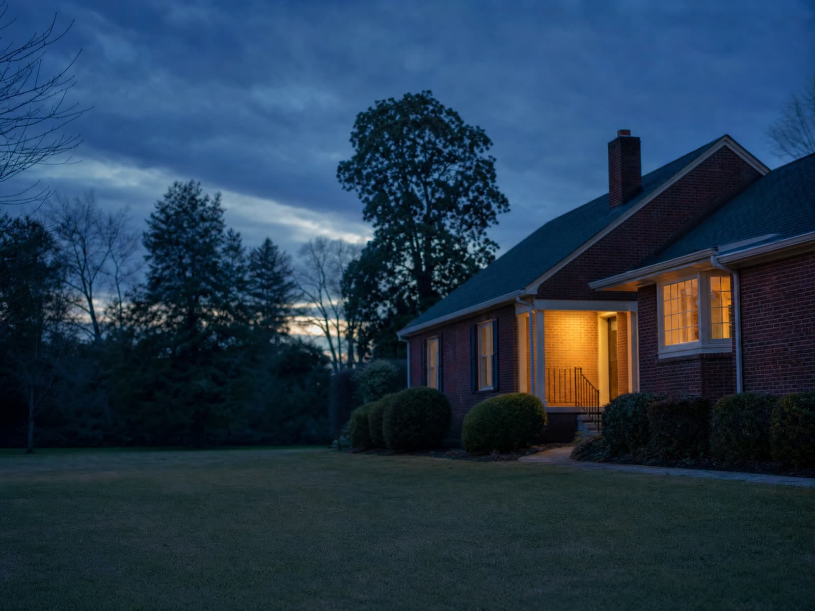 A calm house at dusk with one porch light on, a family matter resolving with dignity.